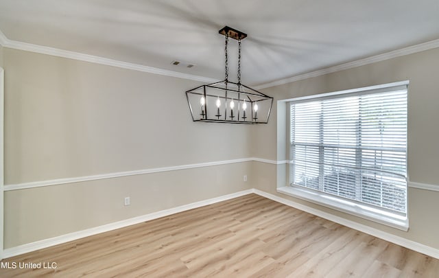 spare room featuring an inviting chandelier, crown molding, and light wood-type flooring