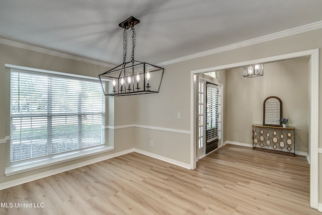 unfurnished dining area featuring crown molding, light hardwood / wood-style flooring, and a notable chandelier