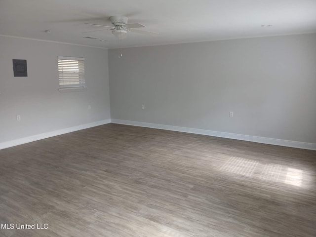 empty room with hardwood / wood-style floors, electric panel, and ceiling fan