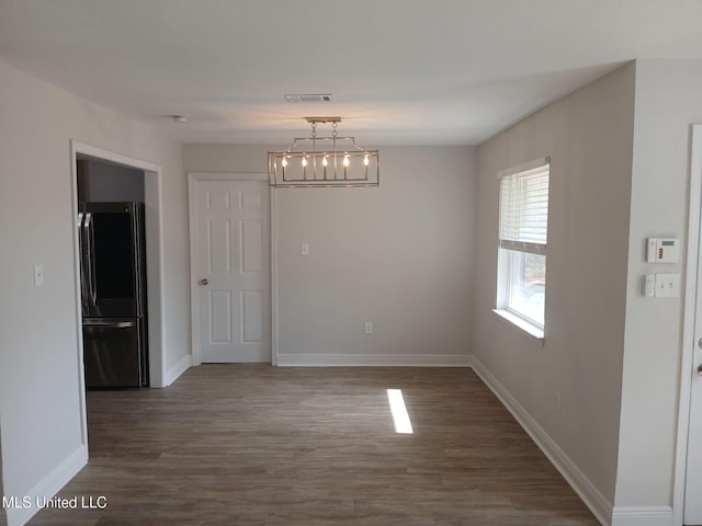 unfurnished dining area with dark wood-type flooring