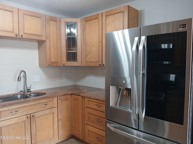 kitchen with light brown cabinetry, tasteful backsplash, sink, stainless steel fridge with ice dispenser, and light stone countertops