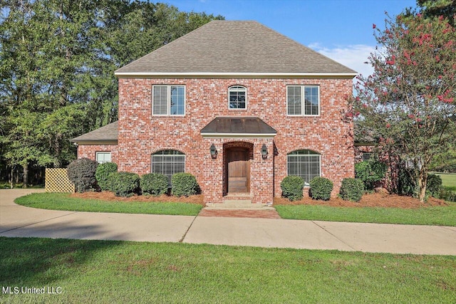 colonial inspired home with a front lawn