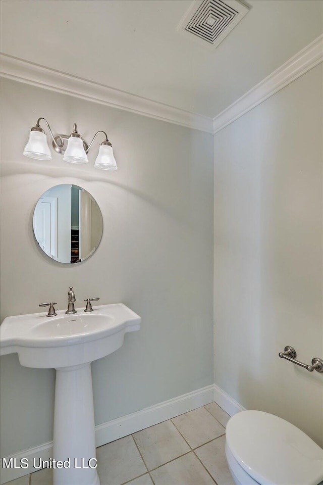 bathroom with toilet, crown molding, and tile patterned floors