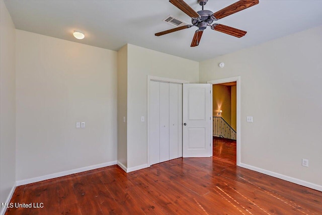 unfurnished bedroom with dark wood-type flooring, a closet, and ceiling fan