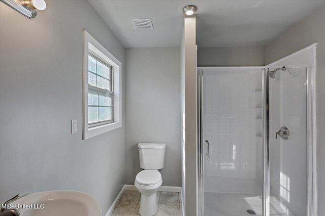 bathroom featuring toilet and an enclosed shower