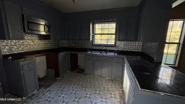 kitchen featuring decorative backsplash, gray cabinets, and sink