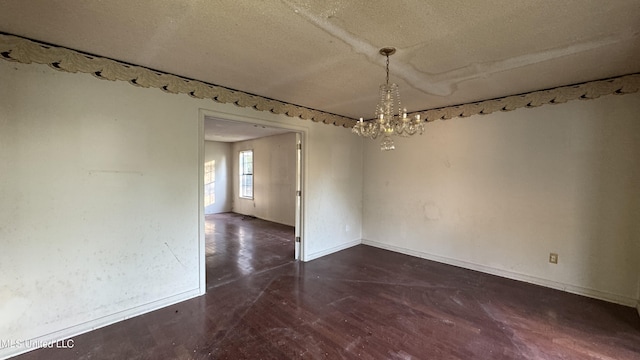 unfurnished dining area featuring a textured ceiling and a notable chandelier