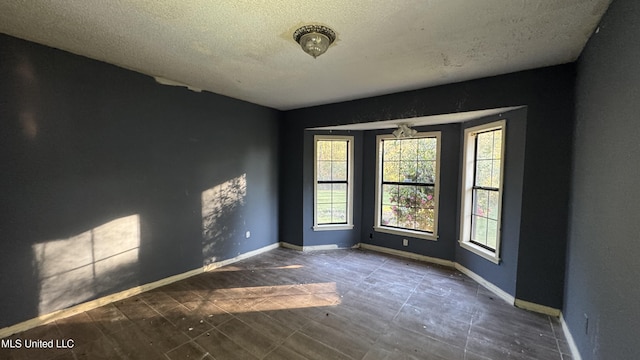 unfurnished room featuring a textured ceiling