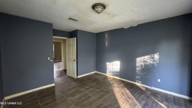 spare room with a textured ceiling