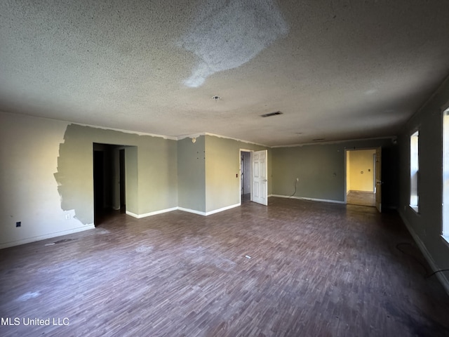 spare room with a textured ceiling and dark wood-type flooring