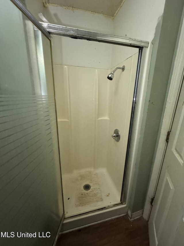 bathroom featuring hardwood / wood-style flooring and a shower with door