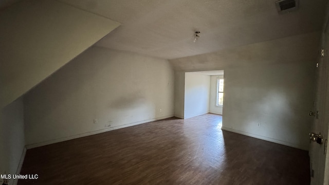 additional living space with dark hardwood / wood-style flooring and lofted ceiling