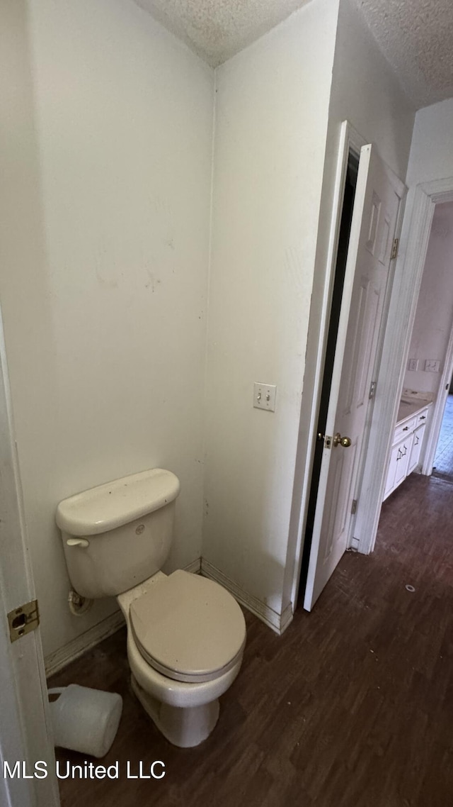 bathroom with toilet, a textured ceiling, and hardwood / wood-style flooring