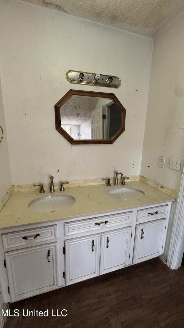 bathroom featuring hardwood / wood-style floors, vanity, and a textured ceiling