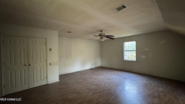 interior space featuring a textured ceiling, ceiling fan, vaulted ceiling, and dark hardwood / wood-style floors