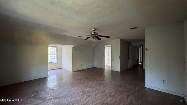 interior space with a textured ceiling, ceiling fan, dark wood-type flooring, and vaulted ceiling