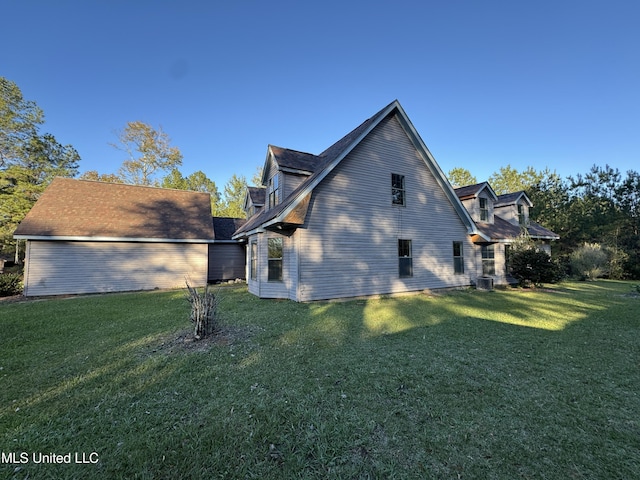 view of side of property with a lawn and central AC