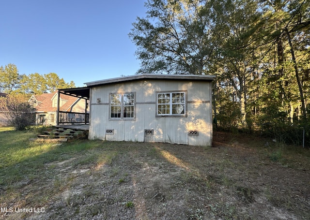 view of side of home with a lawn and covered porch