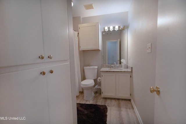 bathroom with vanity, toilet, and hardwood / wood-style floors