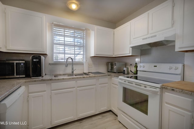 kitchen with tasteful backsplash, white cabinetry, sink, and white appliances