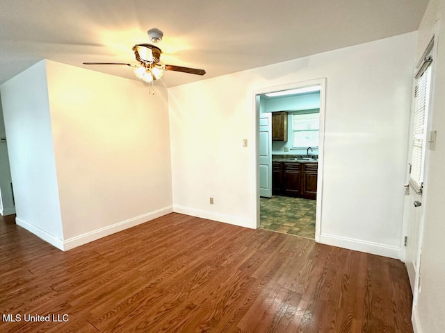 6 Dogwood Cir, Diamondhead, MS 39525 - spare room with dark wood-style floors, a ceiling fan, baseboards, and a sink