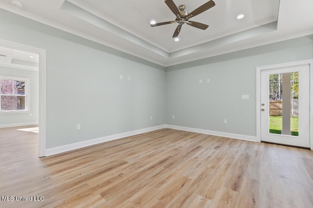 unfurnished room with ornamental molding, a tray ceiling, ceiling fan, and light hardwood / wood-style floors