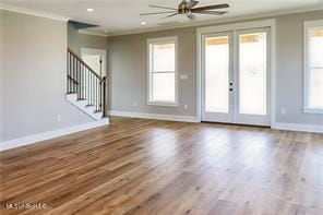 0 N Daytona Dr, Pearlington, MS 39572 - unfurnished living room featuring crown molding, stairway, wood finished floors, a ceiling fan, and french doors