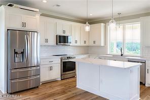 0 N Daytona Dr, Pearlington, MS 39572 - kitchen featuring appliances with stainless steel finishes, a center island, light countertops, and white cabinets