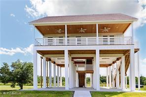 0 N Daytona Dr, Pearlington, MS 39572 - back of property featuring a ceiling fan, a yard, and a balcony