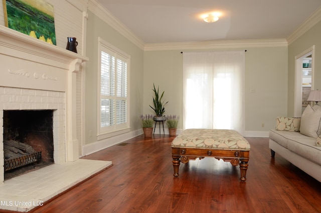 living area featuring a brick fireplace, baseboards, crown molding, and wood finished floors