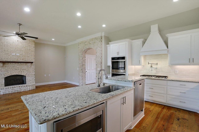 kitchen featuring sink, a kitchen island with sink, and white cabinetry