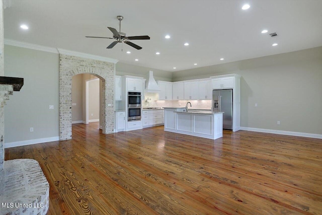 kitchen with dark hardwood / wood-style floors, white cabinetry, stainless steel appliances, and an island with sink