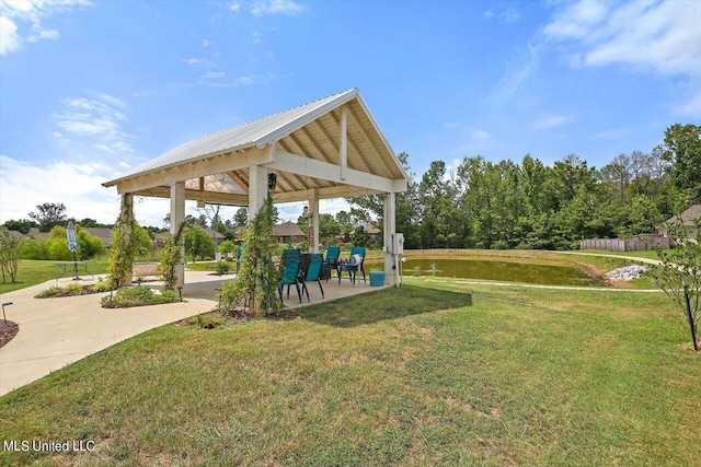 view of property's community featuring a water view, a gazebo, a lawn, and a patio area