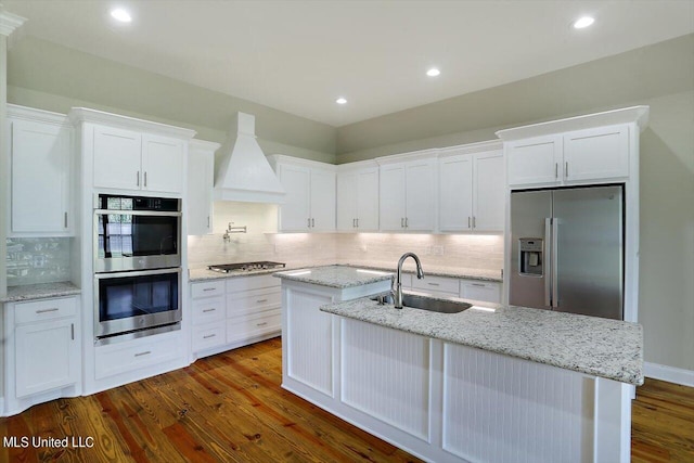 kitchen with sink, premium range hood, stainless steel appliances, and white cabinetry