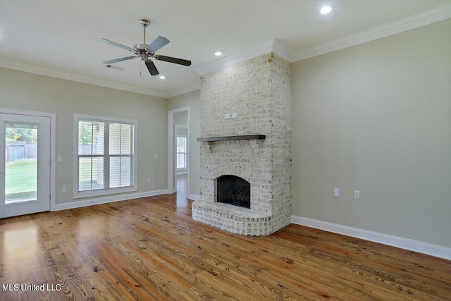 unfurnished living room featuring crown molding, hardwood / wood-style flooring, a fireplace, and ceiling fan