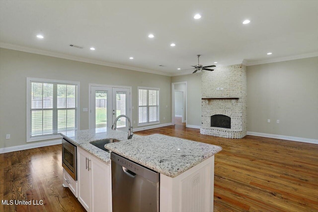 kitchen featuring a kitchen island with sink, light stone countertops, white cabinetry, appliances with stainless steel finishes, and dark hardwood / wood-style flooring