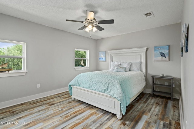 4113 Blue Jay St, Bay Saint Louis, MS 39520 - bedroom featuring multiple windows, hardwood / wood-style flooring, and a textured ceiling