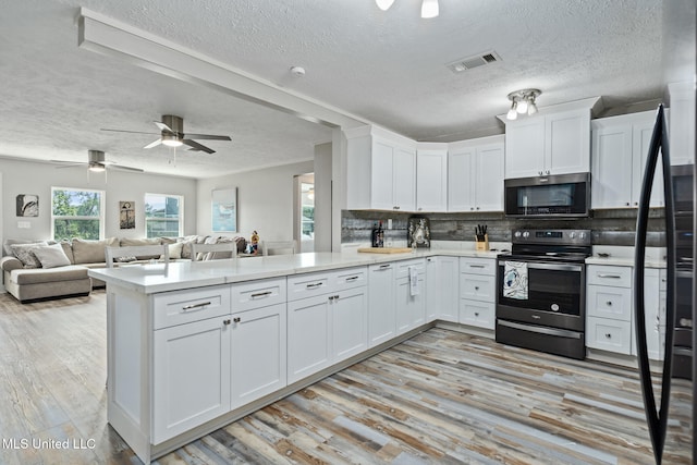 4113 Blue Jay St, Bay Saint Louis, MS 39520 - kitchen featuring white cabinetry, appliances with stainless steel finishes, and kitchen peninsula