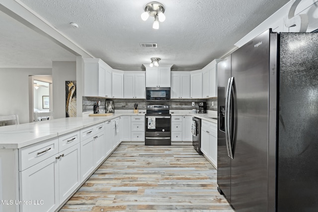 4113 Blue Jay St, Bay Saint Louis, MS 39520 - kitchen with white cabinetry, appliances with stainless steel finishes, and kitchen peninsula