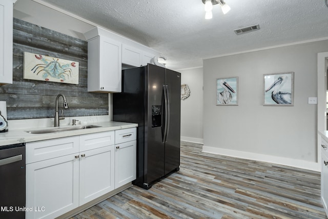 4113 Blue Jay St, Bay Saint Louis, MS 39520 - kitchen with sink, stainless steel appliances, light hardwood / wood-style floors, a textured ceiling, and white cabinets