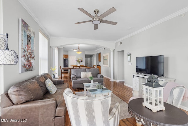 living room featuring decorative columns, crown molding, hardwood / wood-style flooring, and ceiling fan