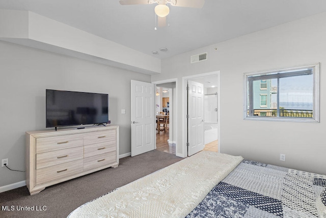 bedroom featuring dark carpet, connected bathroom, and ceiling fan