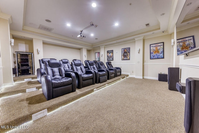 home theater room with a tray ceiling, ornamental molding, and carpet floors