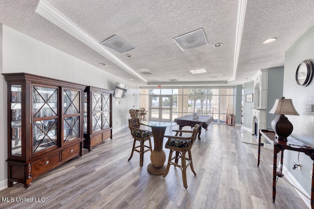 dining space with french doors, a textured ceiling, and light hardwood / wood-style floors