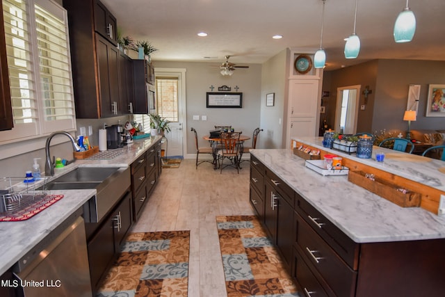 kitchen featuring light hardwood / wood-style floors, dishwasher, decorative light fixtures, and plenty of natural light