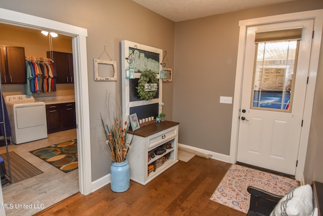 entrance foyer featuring washer / clothes dryer, a textured ceiling, and wood-type flooring