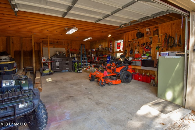 garage featuring wooden walls and a workshop area