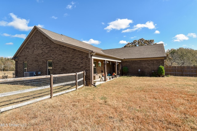 view of side of home with a patio, cooling unit, and a yard