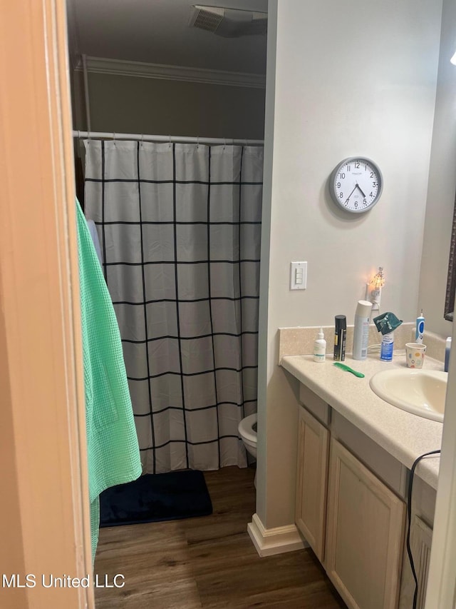 bathroom featuring hardwood / wood-style floors, vanity, ornamental molding, toilet, and a shower with shower curtain