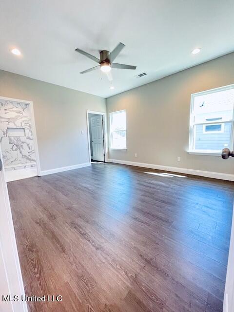 spare room featuring dark wood-type flooring and ceiling fan